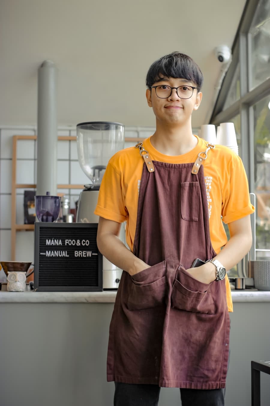 Barista kafe sedang bertugas — staf F&B yang operasionalnya terpantau FirstPayroll